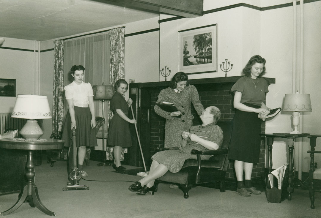 A black and white photograph of women doing chores in the Love Hall parlor