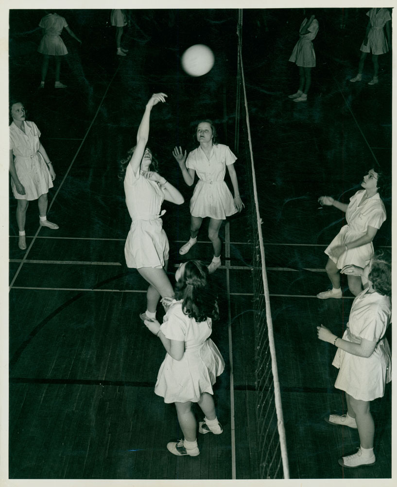 A black and white image of women playing volleyball