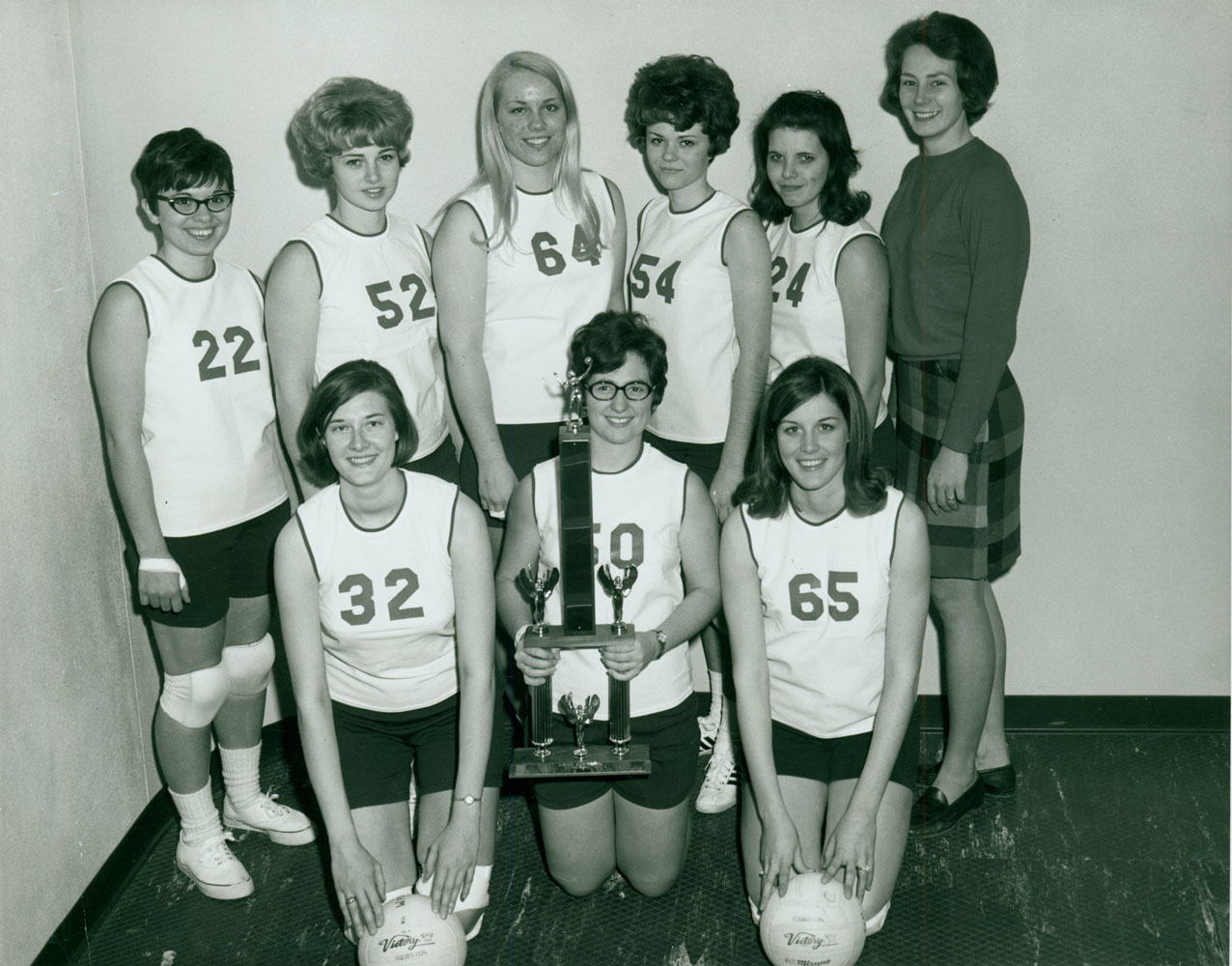 A black and white group portrait of women wearing sports jerseys