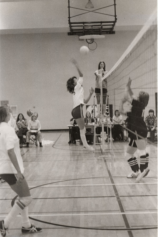 A black and white image of women playing volleyball