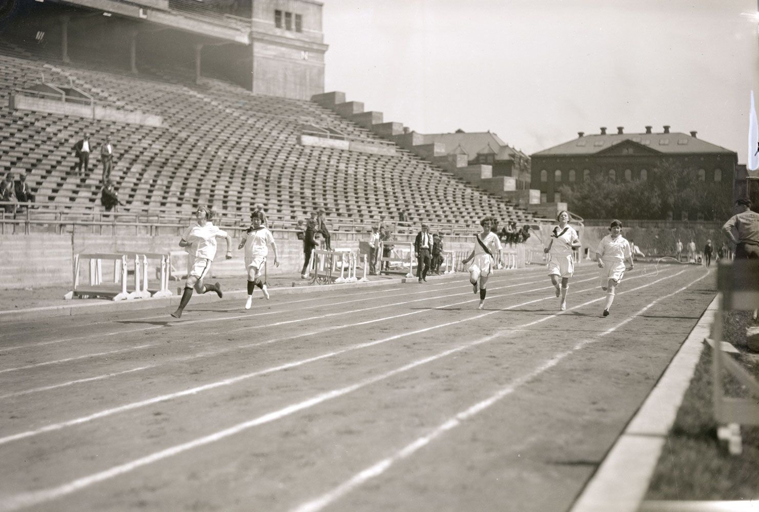 A black and white image of women running on a track