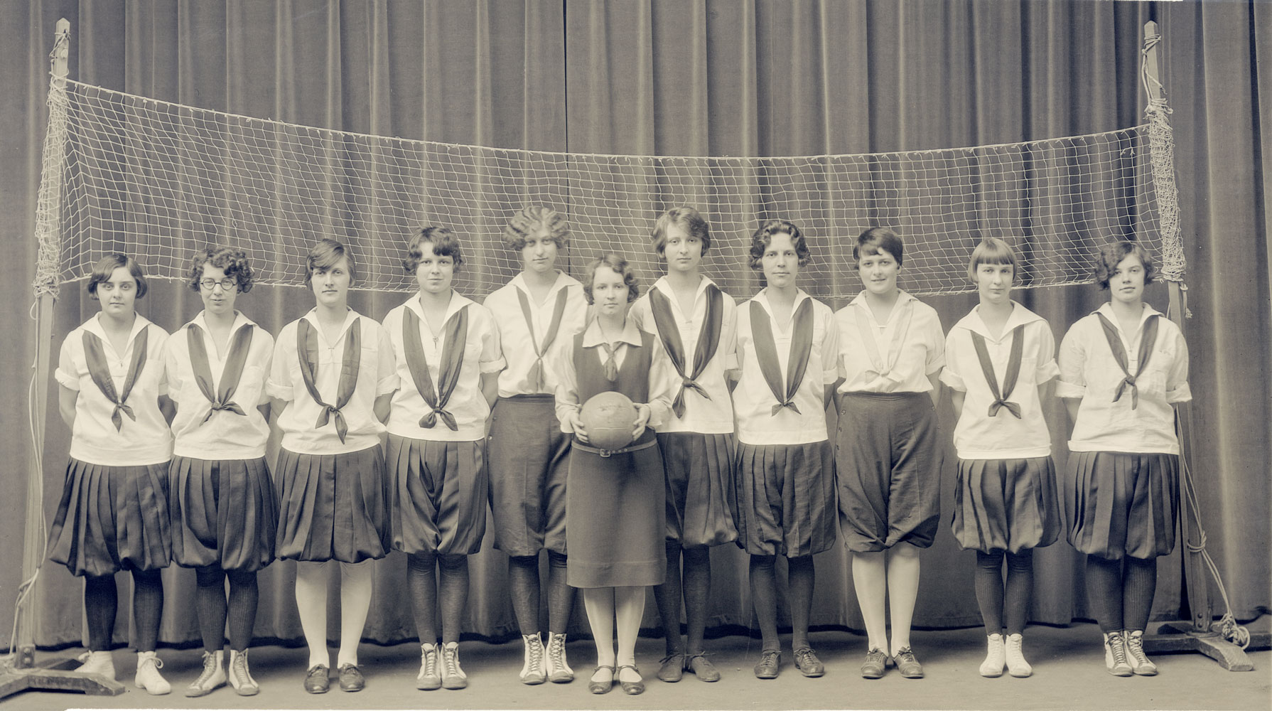 A black and white group portrait of a volleyball team